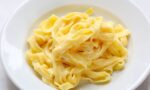 Tereyağı ve Parmigiano ile hazırlanmış orijinal fettuccine Alfredo, beyaz derin tabakta