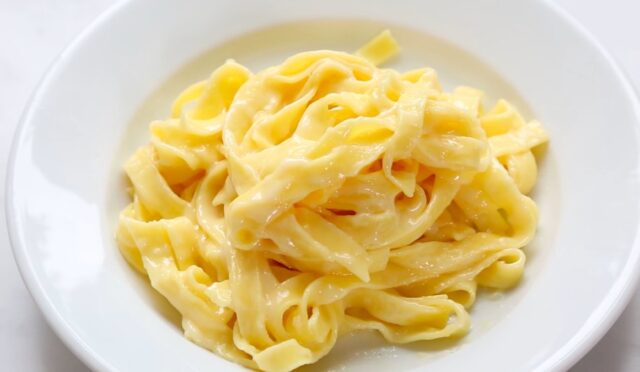 Tereyağı ve Parmigiano ile hazırlanmış orijinal fettuccine Alfredo, beyaz derin tabakta