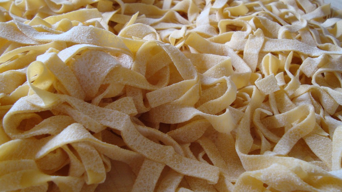 Fettuccine Alfredo için unlanmış taze yumurtalı fettuccine şeritleri