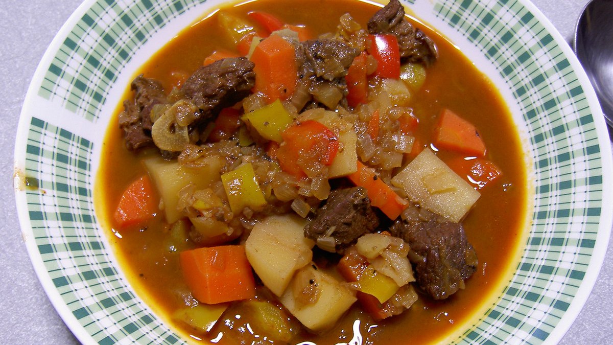 Dana eti, patates, havuç ve biberle dolu kıvamlı gulyás çorbası tabağı