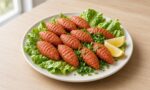 Marul yaprakları üzerinde elle sıkılmış mercimek köfteleri, limon dilimleri ve taze yeşillikle sade bir tabakta
