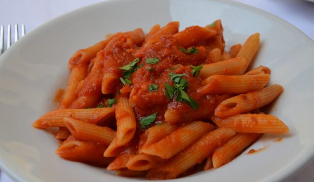 Penne arrabbiata tarifi: acılı domates soslu penne, kıyılmış maydanozla beyaz derin tabakta