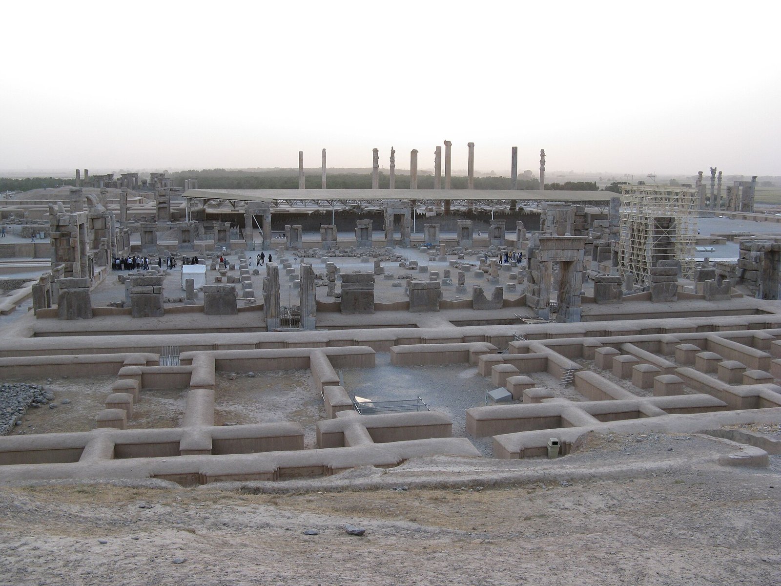 Persepolis terasının Kuh-e Rahmet yamacından görünümü, önde temel kalıntıları ve geride ayakta kalan sütunlar